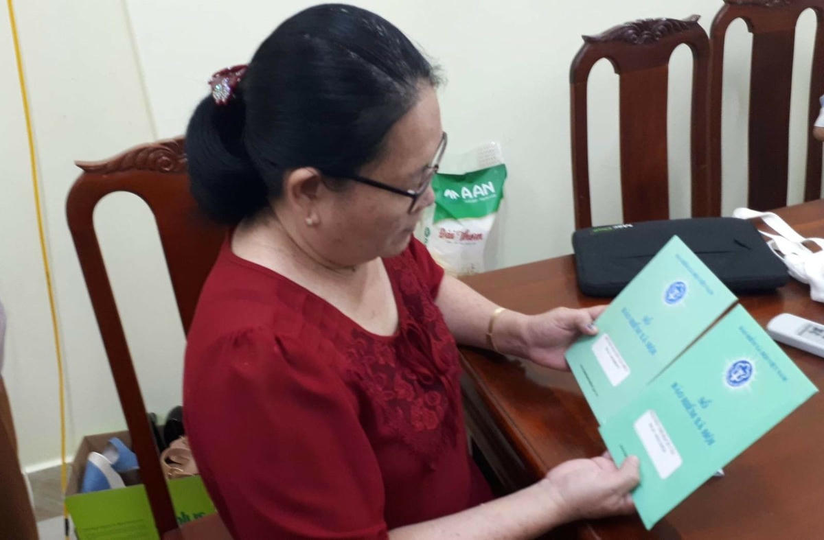 Người lao động cầm trên tay sổ BHXH.