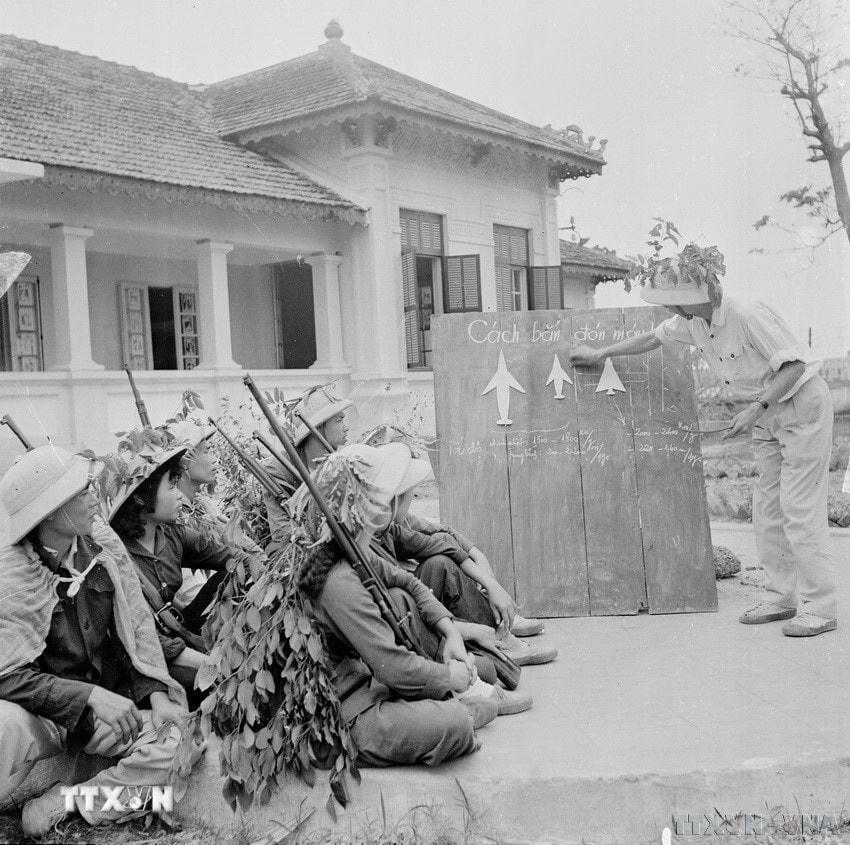 Đồng chí Nguyễn Xuân Tảo, bộ đội phục viên, trung đội trưởng đội dân quân tự vệ bệnh viện Hà Đông chia sẻ kinh nghiệm bắn máy bay cho tổ săn máy bay của bệnh viện. (Ảnh: Thanh Tụng/TTXVN)