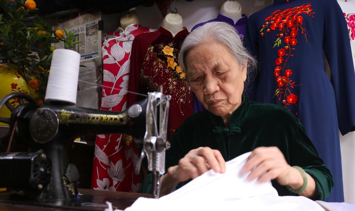 Bà Quyến miệt mài may áo dài cho khách (ảnh Trung Nguyễn)
