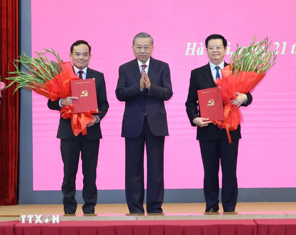 Tổng Bí thư, Chủ tịch nước Tô Lâm trao Quyết định phân công nhiệm vụ của Bộ Chính trị và tặng hoa chúc mừng các đồng chí Trần Lưu Quang (bên trái), Trưởng Ban Kinh tế Trung ương và Mai Văn Chính (bên phải), Trưởng Ban Dân vận Trung ương. (Ảnh: Trí Dũng/TTXVN) TTXVN_2108Bochinhtri3.jpg