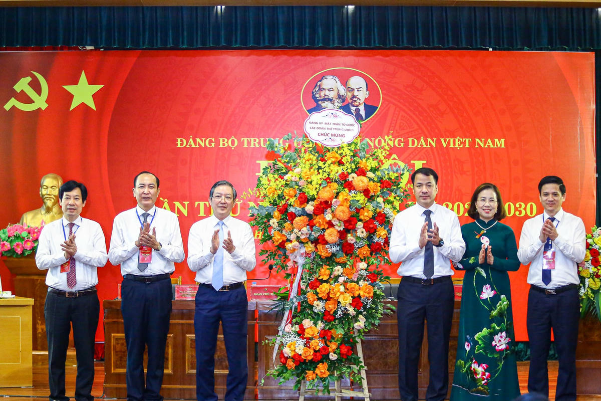 Ông Ngô Văn Cương, Phó Bí thư Đảng ủy MTTQ, các đoàn thể Trung ương tặng hoa chúc mừng Ban Thường vụ Đảng ủy Trung ương Hội Nông dân Việt Nam. Ảnh: Quang Vinh