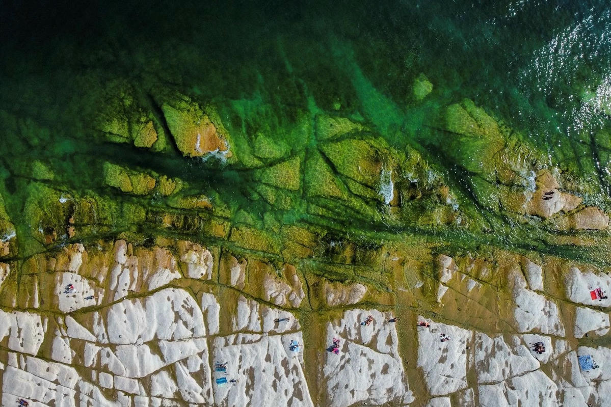 Đá ngầm nổi lên từ mặt nước của Hồ Garda ở Sirmione sau khi miền Bắc Italy trải qua đợt hạn hán tồi tệ nhất trong 70 năm. Ảnh: Flavio Lo Scalzo / Reuters.