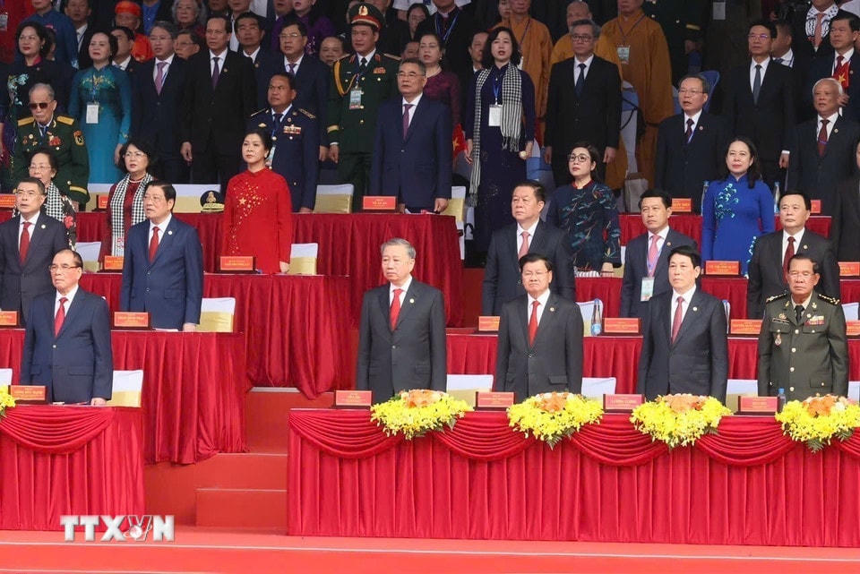 Các đai biểu thực hiện nghi lễ chào cờ. (Ảnh: TTXVN)