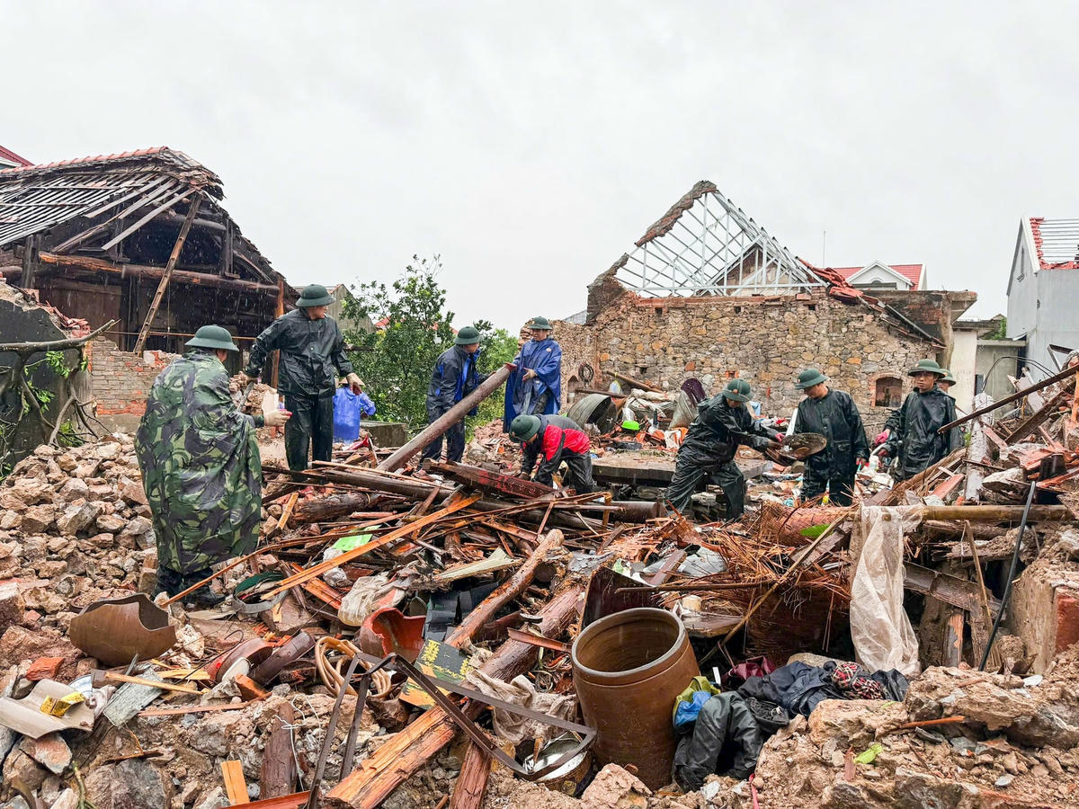 Bộ đội, Công an tỉnh Ninh Bình giúp người dân phường Lý Thường Kiệt thu dọn nhà cửa sau trận giông lốc. Ảnh: V.T