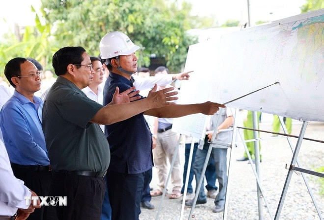 Thủ tướng Phạm Minh Chính nghe báo cáo tiến độ thi công tuyến đường cao tốc Châu Đốc - Cần Thơ-Sóc Trăng, đoạn đi qua xã Đông Thắng, huyện Cờ Đỏ. (Ảnh: Dương Giang/TTXVN) ttxvn-thu-tuong-pham-minh-chinh-cong-trinh-trong-diem-10.jpg