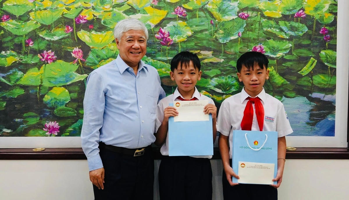 Chủ tịch Đỗ Văn Chiến tặng quà cho các cháu nhỏ. ảnh Đình Sang