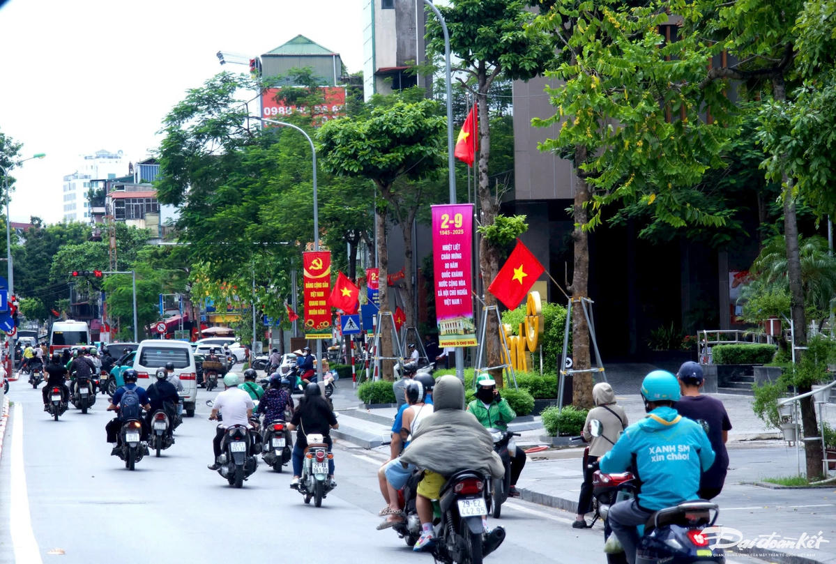Những tấm pano mang thông điệp “Độc lập – Tự do – Hạnh phúc” nổi bật giữa nền xanh cây phố cổ, gợi nhắc hành trình vẻ vang của dân tộc. Nhiều người dân tranh thủ dừng xe chụp ảnh bên cột cờ, hàng hoa để lưu lại khoảnh khắc đặc biệt. Hà Nội không chỉ đẹp bởi màu sắc lễ hội, mà còn ấm áp bởi niềm tự hào đang lan tỏa trong từng ánh mắt, nụ cười. Ảnh: Phạm Sỹ.