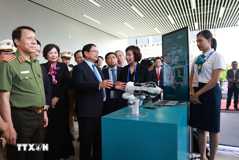 Thủ tướng Phạm Minh Chính tham quan gian hàng trưng bày sản phẩm công nghệ. (Ảnh: Dương Giang/TTXVN)