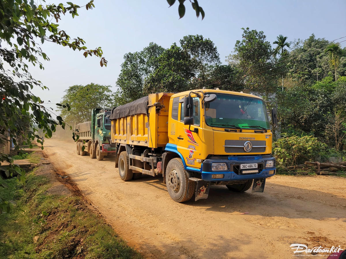 Đoàn xe chở đất nối đuôi nhau trên tỉnh lộ ĐT.523. Ảnh: Đình Minh