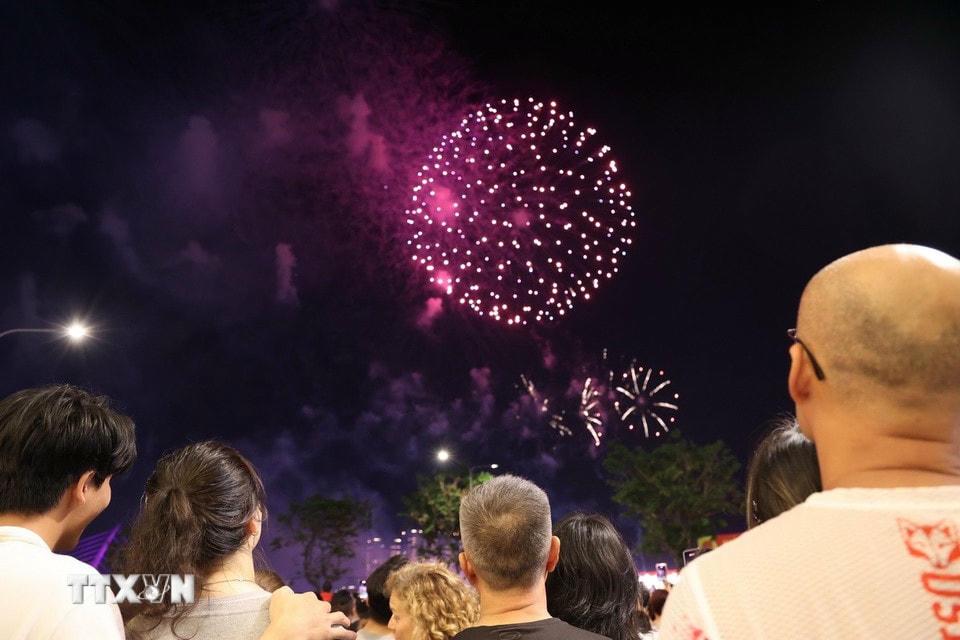 Người dân, du khách xem pháo hoa tại khu vực bến Bạch Đằng (Quận 1). (Ảnh: Thu Hương/TTXVN)