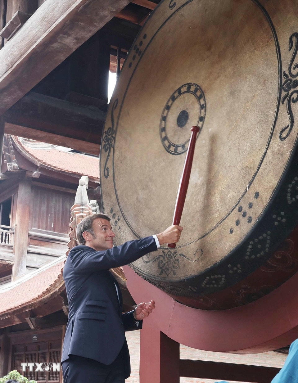Tổng thống Pháp Emmanuel Macron thực hiện nghi lễ đánh trống Sấm trong Văn Miếu-Quốc Tử Giám. (Ảnh: Thống Nhất/TTXVN)