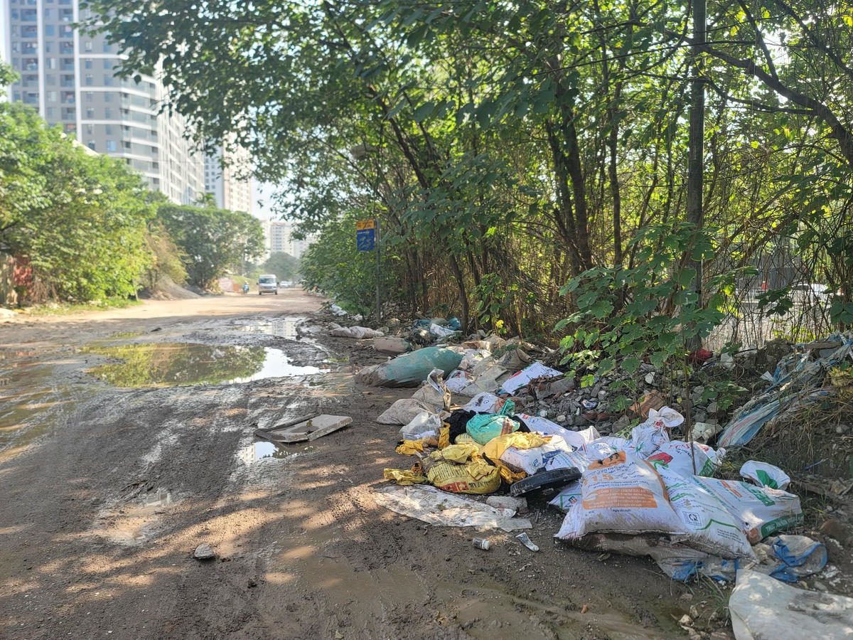 Vị trí điểm chờ e buýt bẩn thỉu với bùn đất nhầy nhụa, rác thải bẩn thỉu, hôi thối.