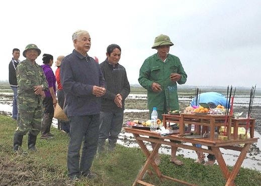 Người dân xã Kỳ Văn thực hiện nghi lễ tâm linh trước khi di dời mộ. Ảnh: Vũ Viễn.