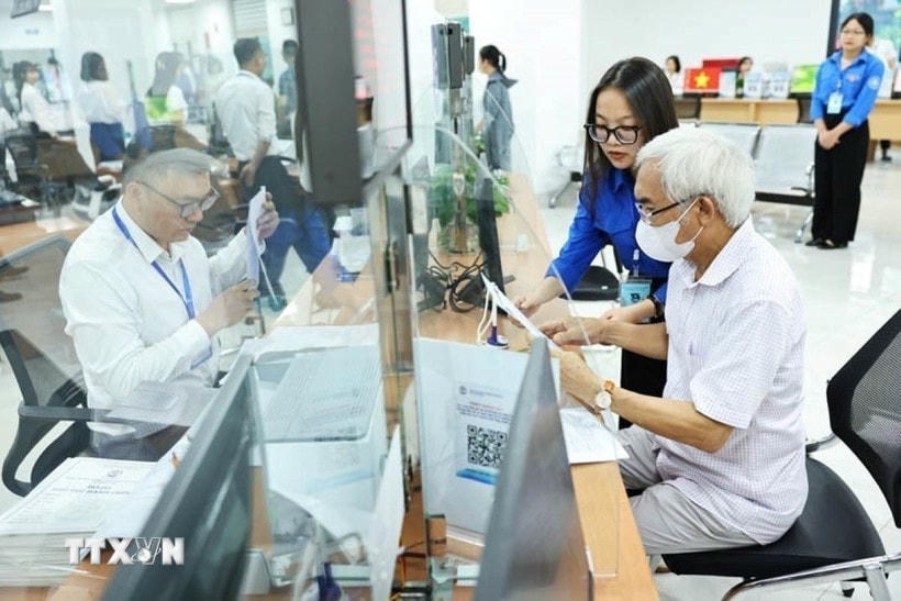 Đội thanh niên tình nguyện hỗ trợ vận hành chính quyền 2 cấp và cung cấp dịch vụ công trực tuyến tại Trung tâm Phục vụ hành chính công phường Cầu Giấy, Hà Nội. (Ảnh: Minh Đức/TTXVN)
