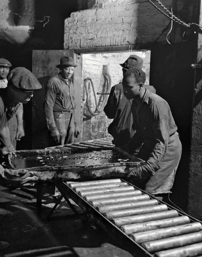 Công nhân đổ một ấm mỡ nóng, sử dụng găng tay amiăng để di chuyển chảo. Ảnh: The Guardian.