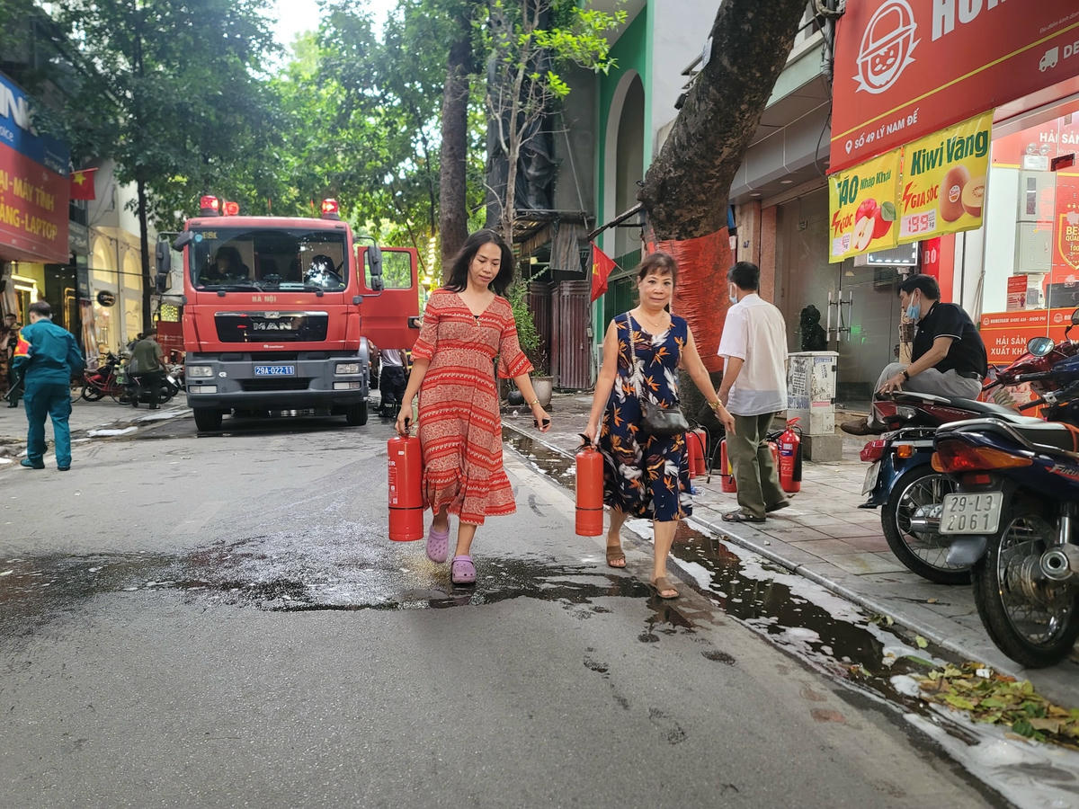 Chị Thu hàng xóm, nghe hô hoán thì chị và mọi người mang bình cứu hỏa ra hỗ trợ dập lửa, nhưng ko ăn thua.