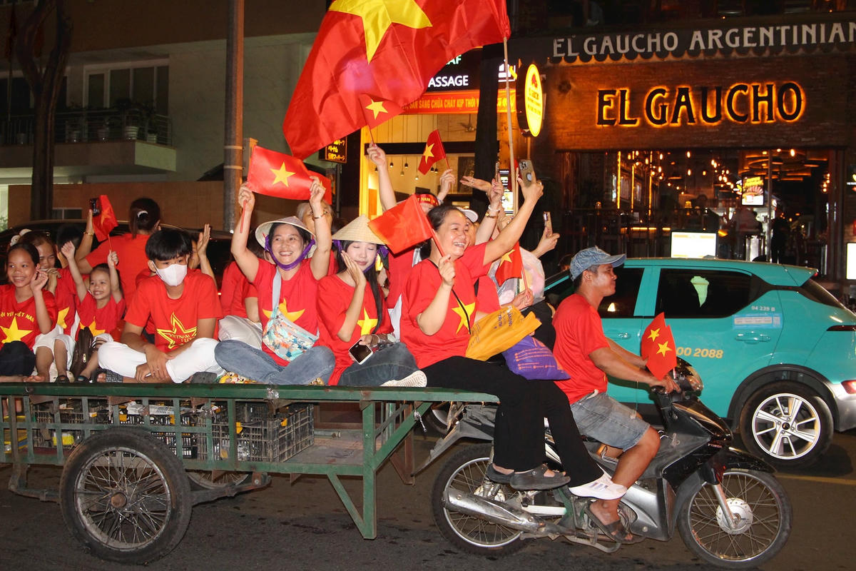 Người dân tự chế xe ba gác chở nhau về trung tâm thành phố để dự lễ kỷ niệm.