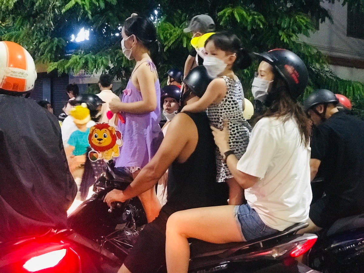 Một gia đình cùng chở nhau đi xem múa lân dịp Tết Trung thu.