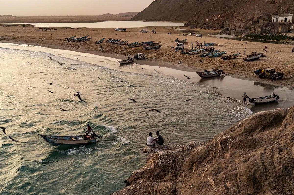 Hai cậu bé nhìn những chiếc thuyền đánh cá rời khỏi Khyseet. Ảnh: The Guardian.