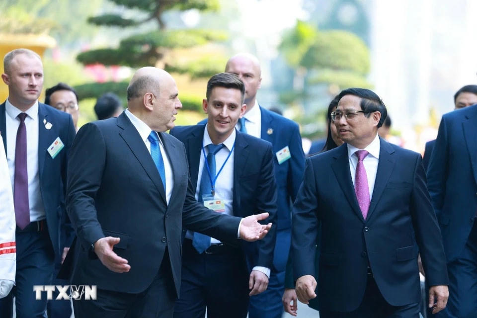 Thủ tướng Phạm Minh Chính và Thủ tướng Liên bang Nga Mikhail Vladimirovich Mishustin trao đổi thân mật. (Ảnh: Dương Giang/TTXVN)