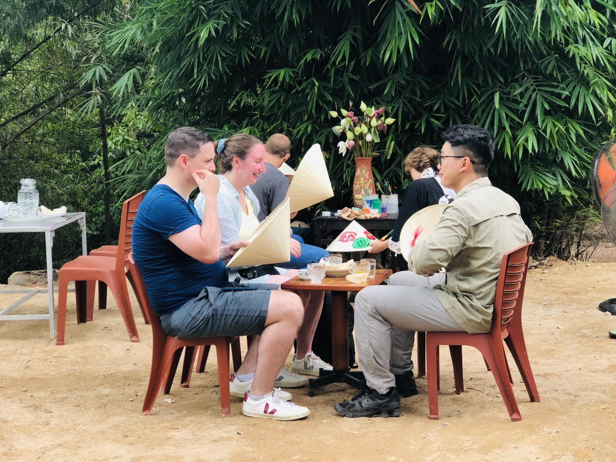 Du khách trải nghiệm vẽ tranh trên nón lá Huế.