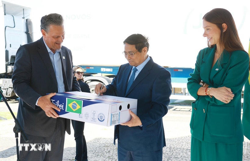 Thủ tướng Phạm Minh Chính ký vào lô hàng thịt bò đầu tiên của Brazil xuất sang Việt Nam. (Ảnh: Dương Giang/TTXVN)