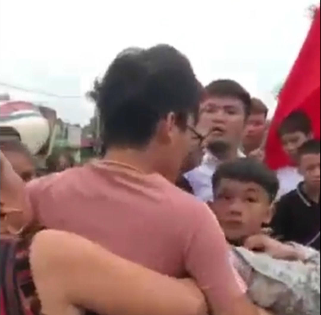 Nam học sinh bị một nhóm người lớn lôi ra cổng để hành hung.