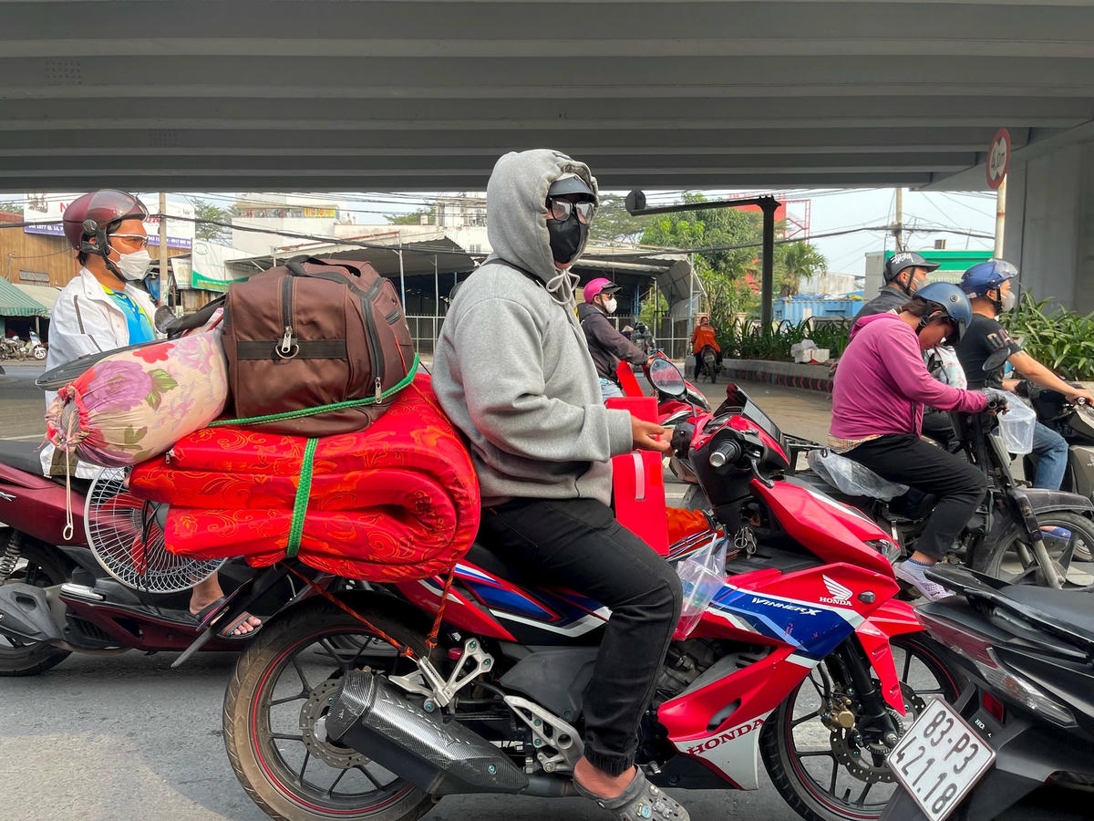 Người dân lỉnh kỉnh đồ đạc trên đường về quê ăn tết.