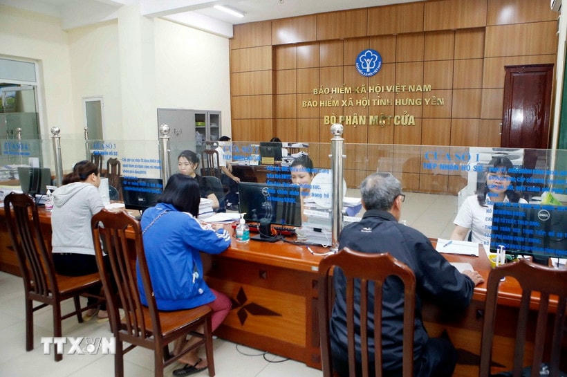 Nhân viên Bảo hiểm Xã hội tỉnh Hưng Yên hướng dẫn người dân làm thủ tục tham gia Bảo hiểm xã hội. (Ảnh: Phạm Kiên/TTXVN)