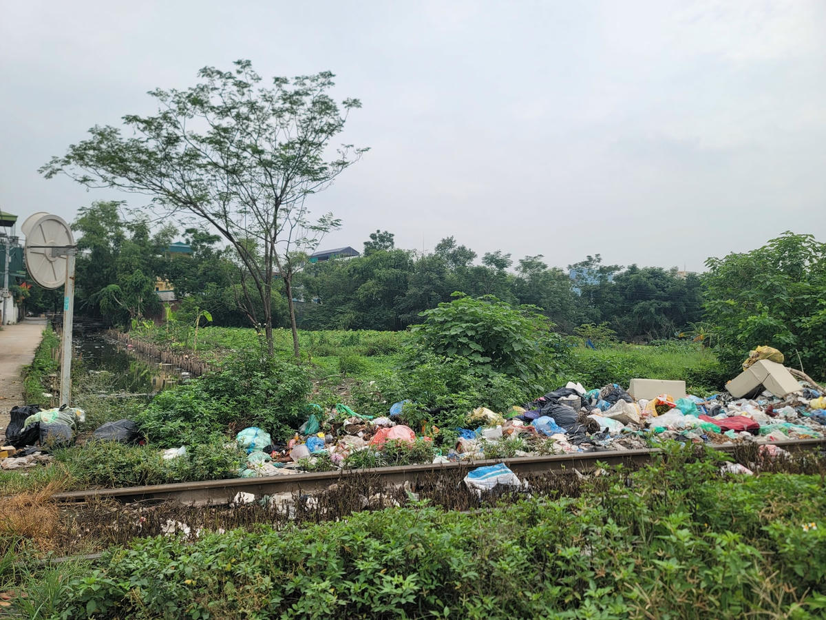 Rác ngập tràn từ trên bờ đê xuống mặt sông.