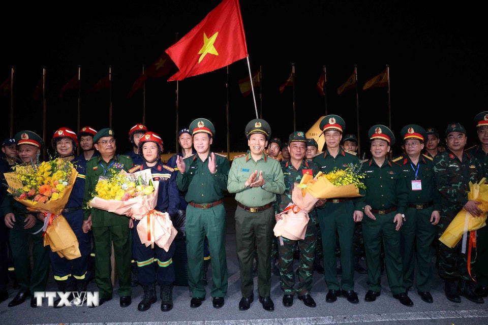 Thượng tướng Vũ Hải Sản, Thứ trưởng Bộ Quốc phòng và Trung tướng Lê Văn Tuyến, Thứ trưởng Bộ Công an đón lực lượng cứu hộ, cứu nạn hoàn thành nhiệm vụ tại Myanmar trở về. (Ảnh: An Đăng/TTXVN)