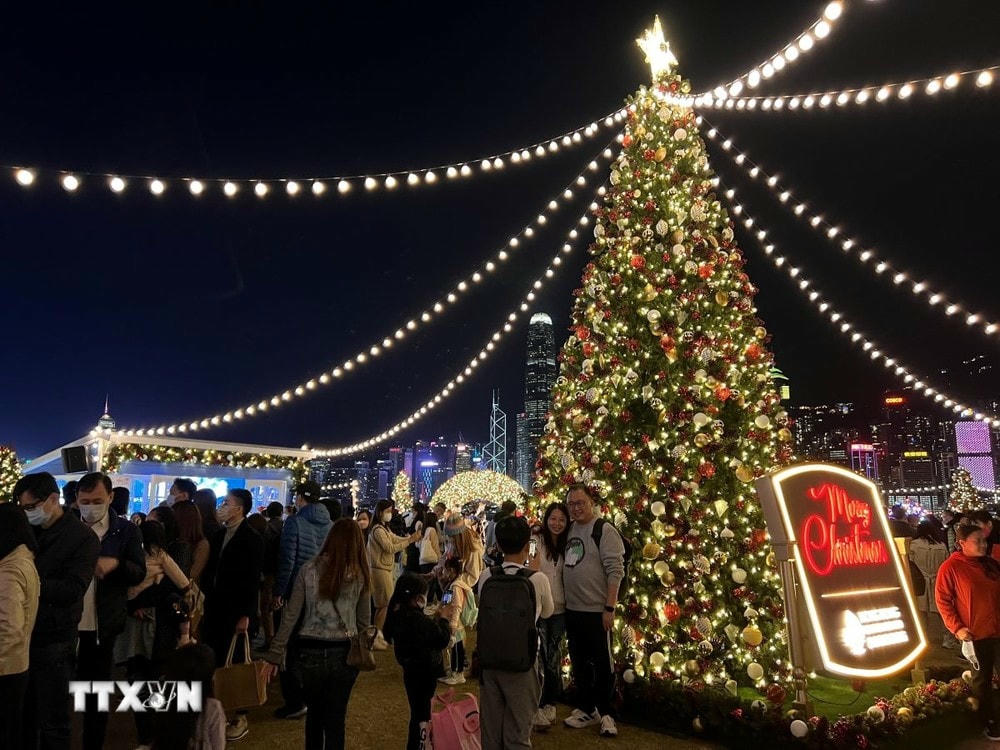 Người dân Hong Kong vui chơi, chụp ảnh bên cây thông Noel. (Ảnh: Mạc Luyện/TTXVN) ttxvn_cay thong (2).jpg