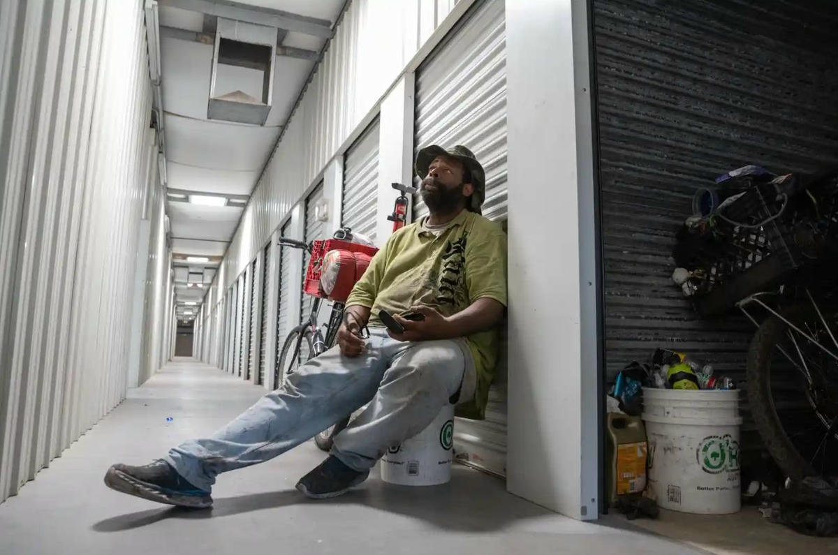 Spell dỡ đồ đạc vào thùng chứa của ông khi nhiệt độ chạm mức 44 độ C. Ảnh: The Guardian.