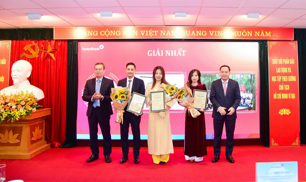 Ông Hồ Xuân Trường - Phó Bí thư Đảng ủy Khối DNTW (bên phải) và ông Trần Minh Bình - Ủy viên Ban Chấp hành Đảng bộ Khối DNTW, Bí thư Đảng ủy, Chủ tịch Hội đồng quản trị NHCTVN (bên trái) trao Giấy chứng nhận và hoa cho các tác giả/nhóm tác giả đạt giải Nhất.