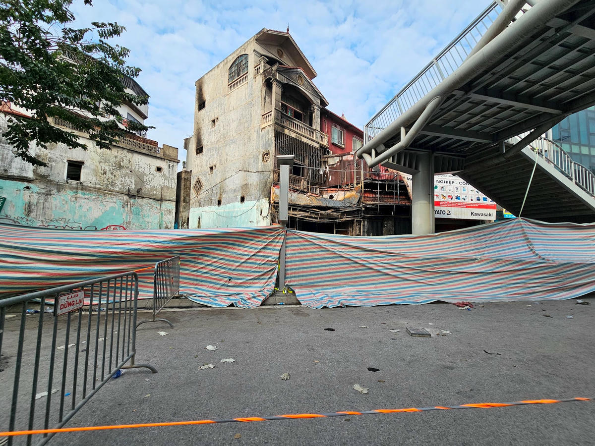 Sáng 19/12, khu vực xảy ra cháy được che bạt, lập rào chắn phục vụ công tác điều tra. Ngôi nhà bị cháy ám khói đen từ tầng 1 tới tầng 4.