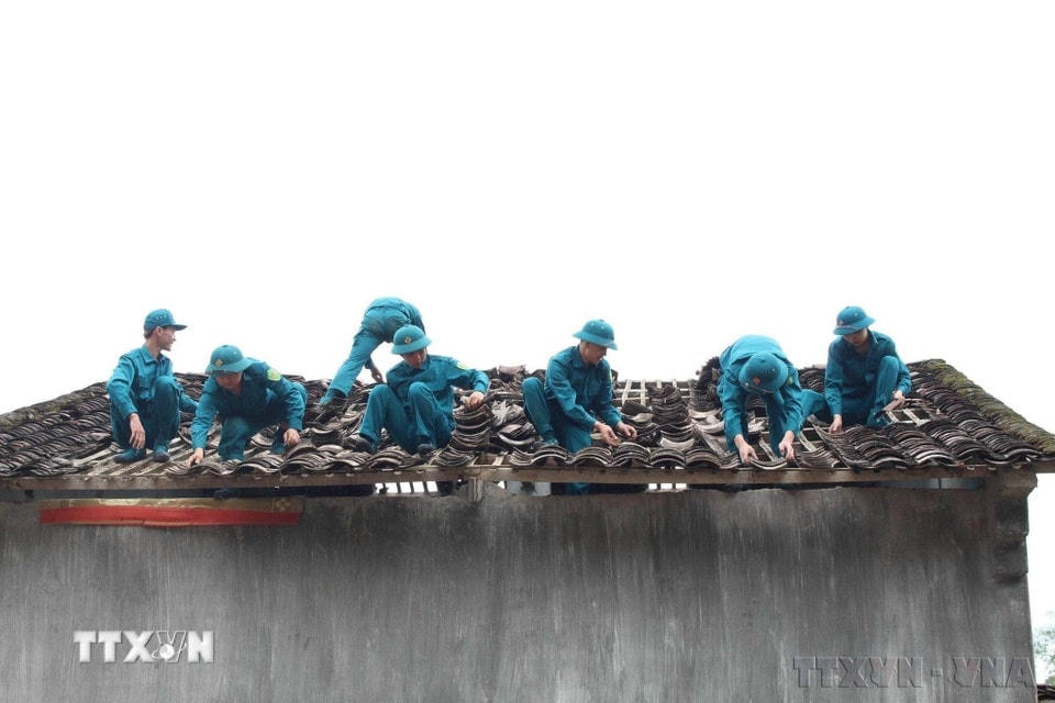 Lực lượng dân quân tự vệ giúp đỡ các gia đình bị thiệt hại lợp lại mái nhà bị hư hỏng do mưa đá tại hai huyện Trùng Khánh, Quảng Hòa và Hà Quảng, tỉnh Cao Bằng, tháng 5/2023. (Ảnh: TTXVN)