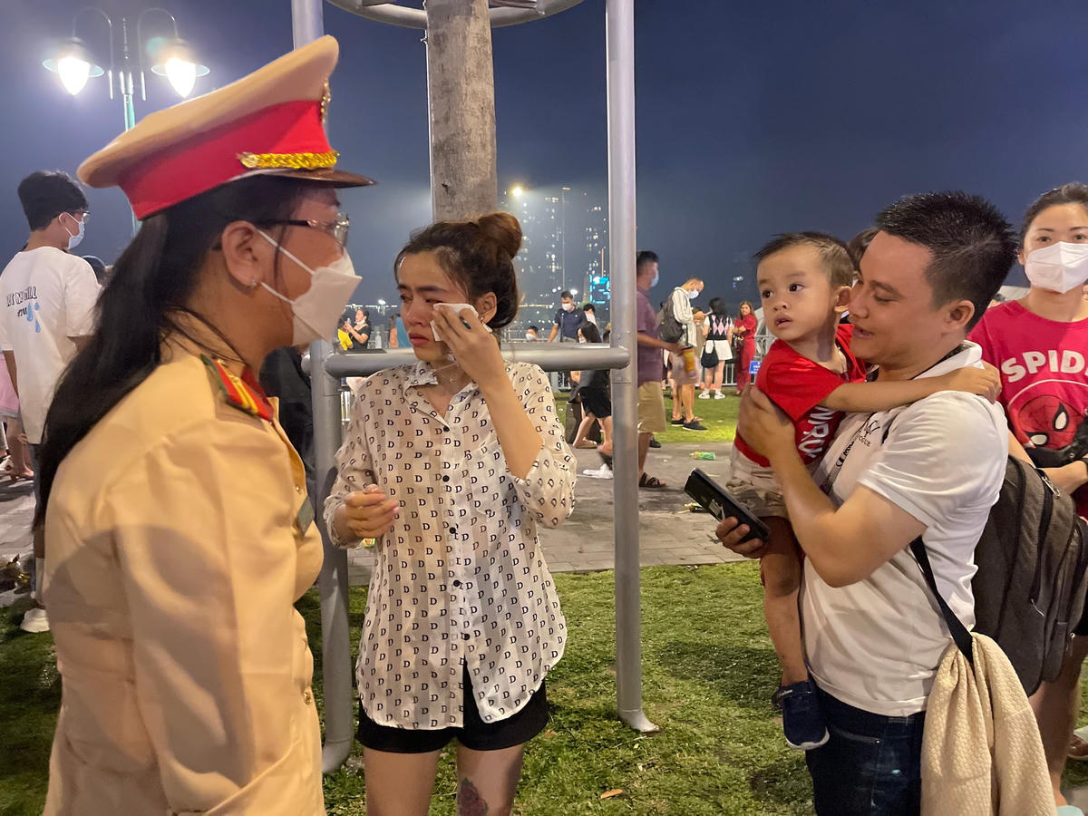 Đồng chí Phạm Thị Kim Tuyến trao lại bé trai bị lạc trong vòng tay cha mẹ.