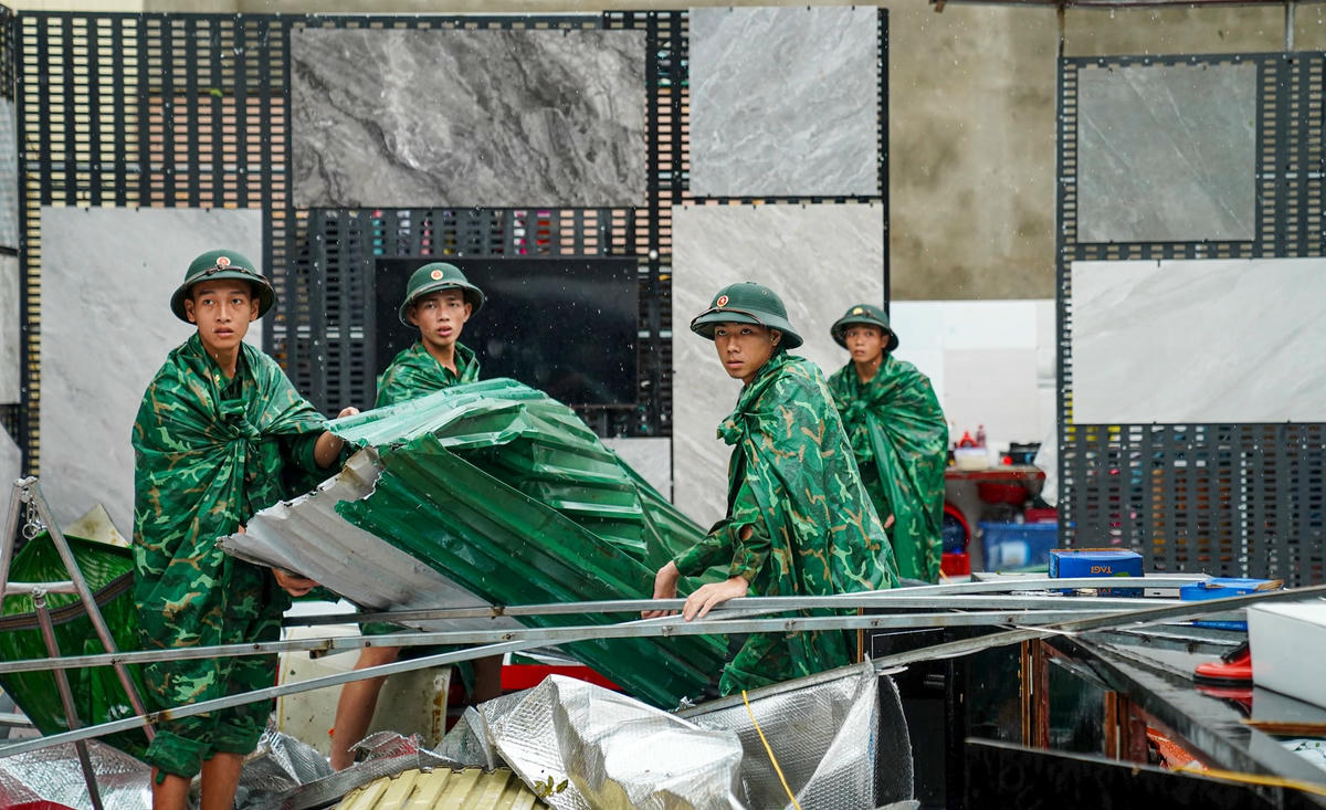 Các cán bộ, chiến sĩ bộ đội biên phòng đến hỗ trợ dọn dẹp giúp gia đình anh Đạo. Ảnh: Cẩm Kỳ