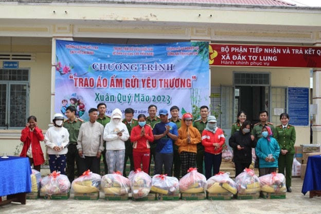Thượng tá Trần Trung Hiếu, Phó trưởng Phòng PC06 Công an TP HCM tặng quà và các cán bộ tặng quà cho người dân.