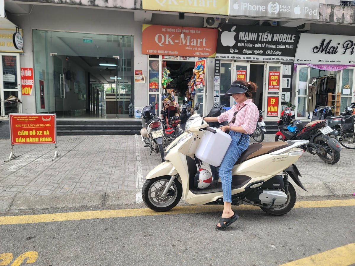 Chị Lê Thị Loan, 34 tuổi, sống tại toà HH03F cho hay, trưa nay tranh thủ về lấy nước nhưng không chờ được, nên giờ đi làm mang theo can để xin nước.