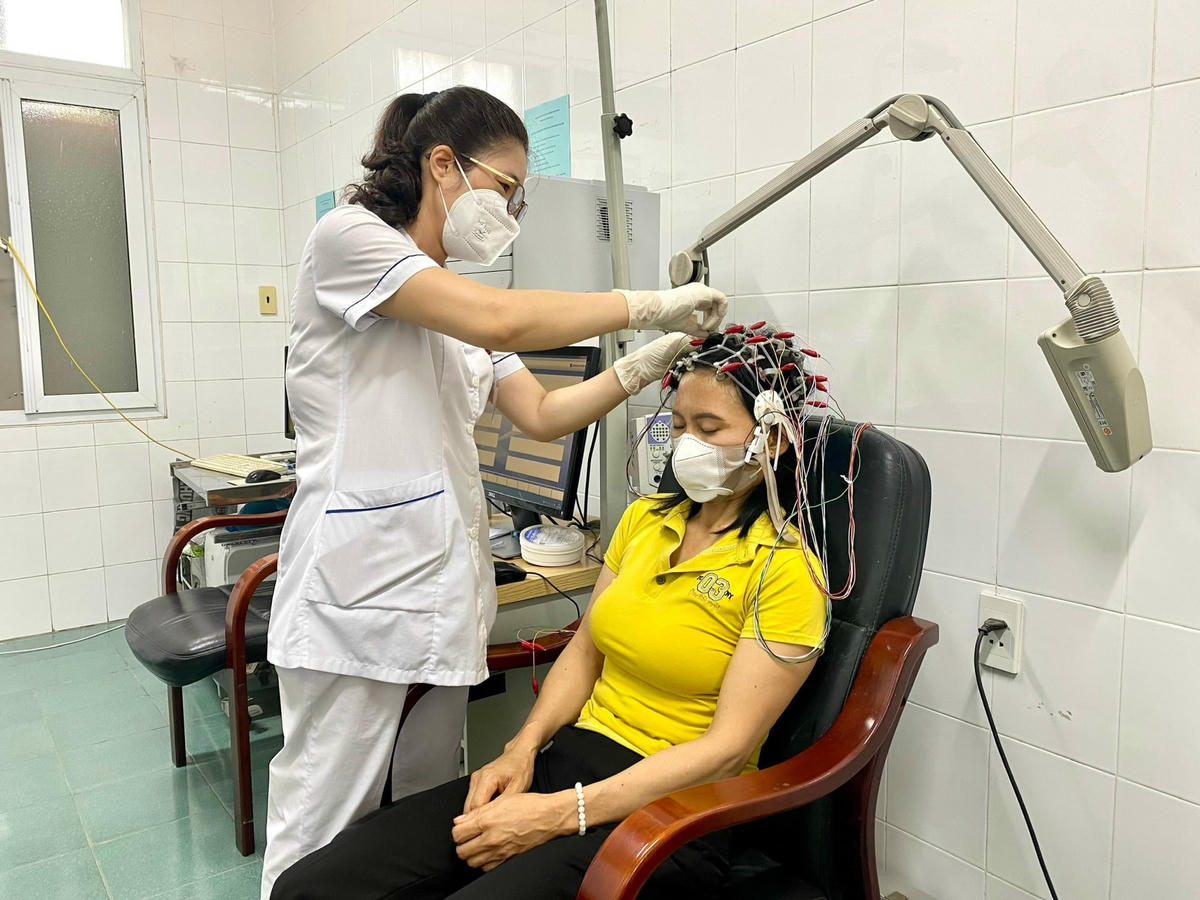 Kỹ thuật viên thực hiện kỹ thuật đo điện não đồ cho bệnh nhân.