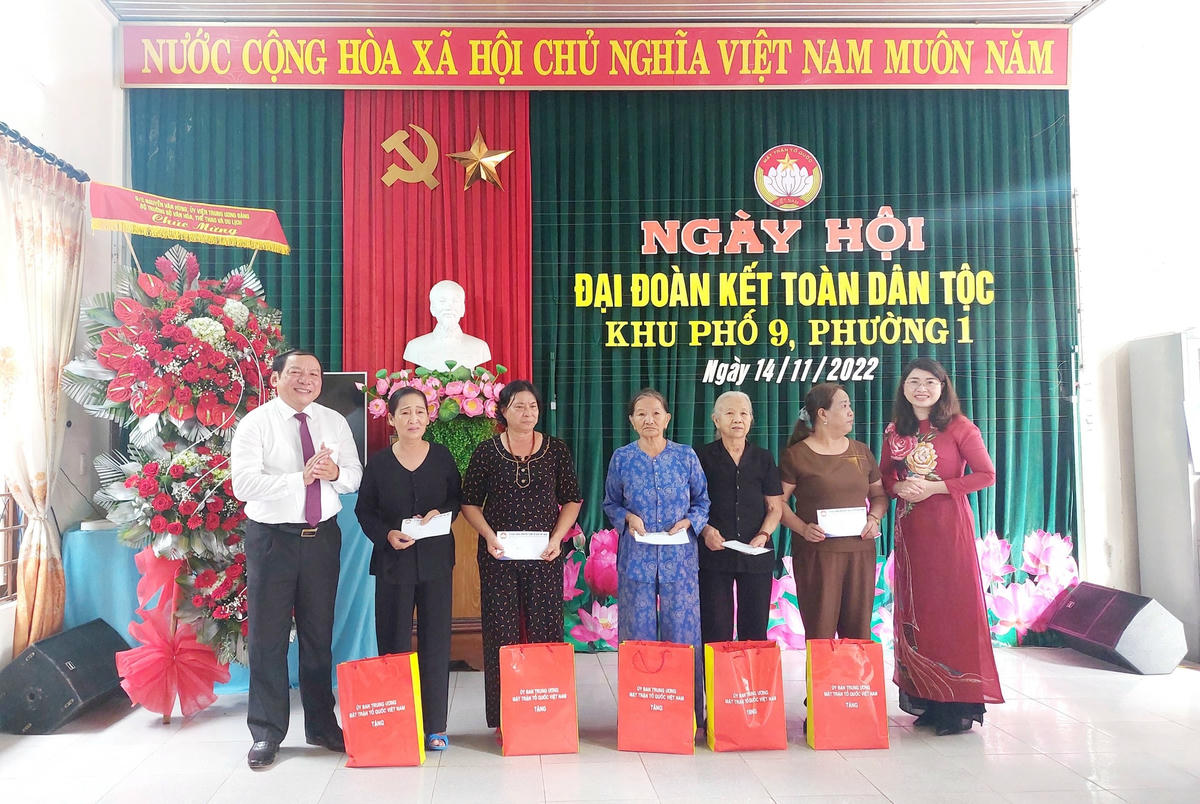 Ông Nguyễn Văn Hùng và bà Nguyễn Ngọc Quỳnh, Phó Trưởng ban Tôn giáo - Ủy ban Trung ương MTTQ Việt Nam (áo dài đỏ) trao quà các phần quà của Ủy ban Trung ương MTTQ Việt Nam đến người dân.