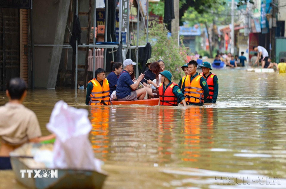 Lực lượng quân đội và dân quân tự vệ xã Bát Tràng, huyện Gia Lâm (Hà Nội) giúp người dân di chuyển và tiếp tế nhu yếu phẩm do ảnh hưởng của mưa lũ, tháng 9/2024. (Ảnh: Thanh Tùng/TTXVN)