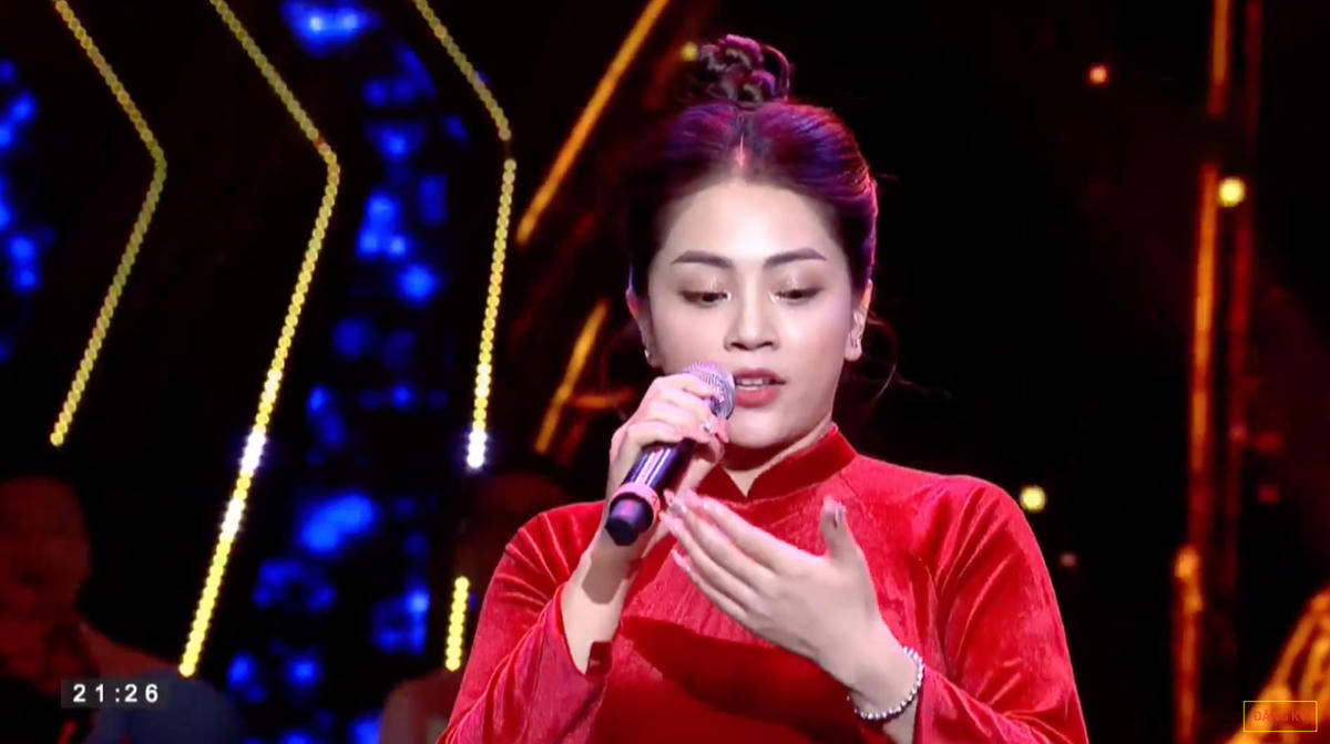 Ca sĩ Khánh Thy liên tục nhìn vào tay để đọc lời khi hát ca khúc “Mười chín tháng Tám”. (ảnh chụp màn hình)