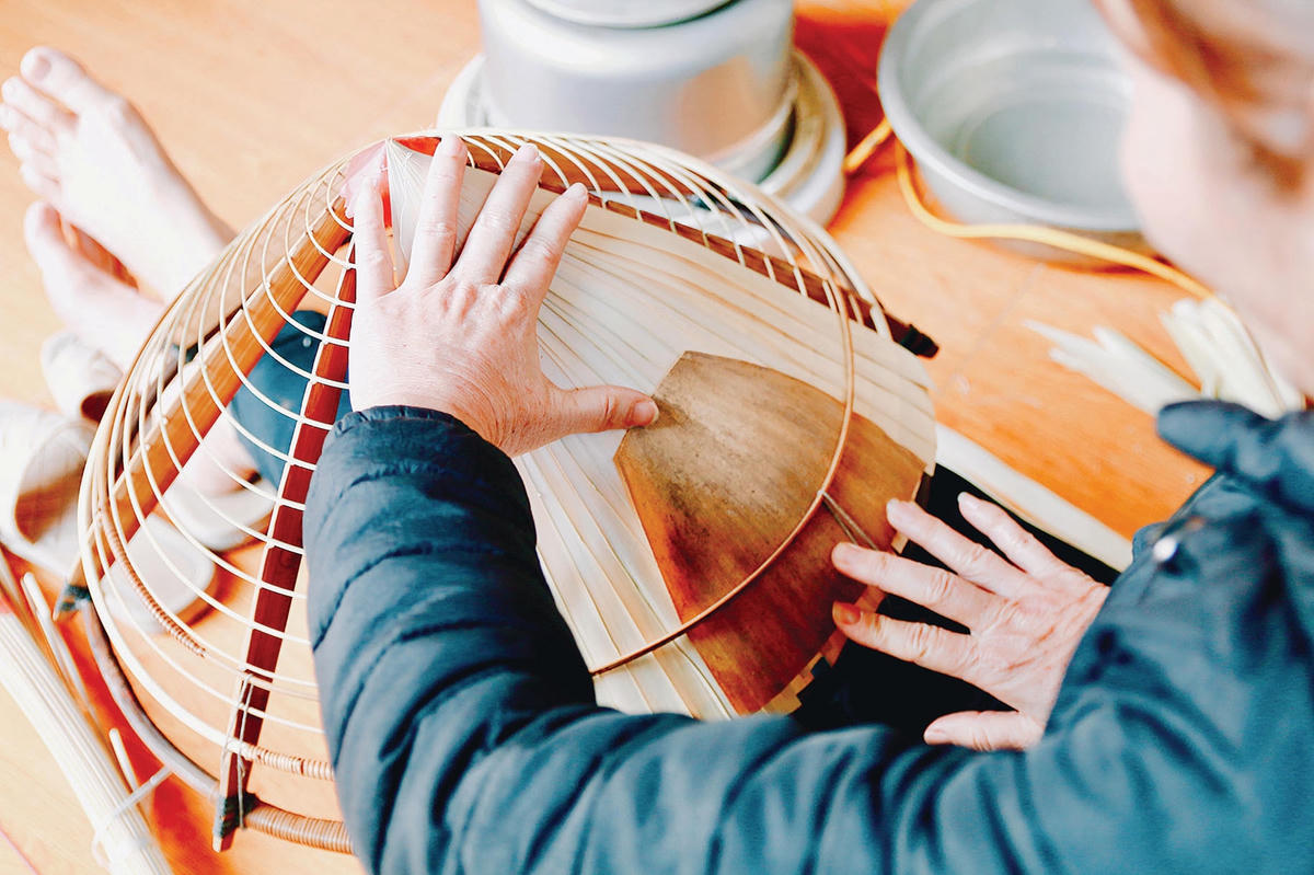 Bằng sự khéo léo và tỉ mỉ, người thợ xếp từng lá cọ vào vòng nón, thêm một lớp mo tre và một lớp lá nứa rồi khâu lại.  