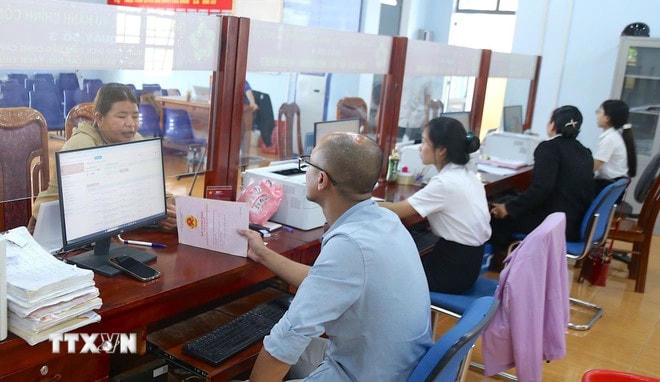 Người dân đến làm các thủ tục hành chính trong ngày 1/7 tại Trung tâm phục vụ hành chính công xã Đức Cơ, tỉnh Gia Lai. (Ảnh: Quang Thái/TTXVN) ttxvn-chinh-quyen-2-cap-di-vao-hoat-dong-0407-1.jpg