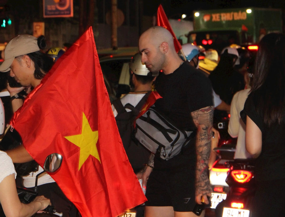 Nhiều người nước ngoài cùng hoà vào dòng người, chung vui niềm lễ kỷ niệm.