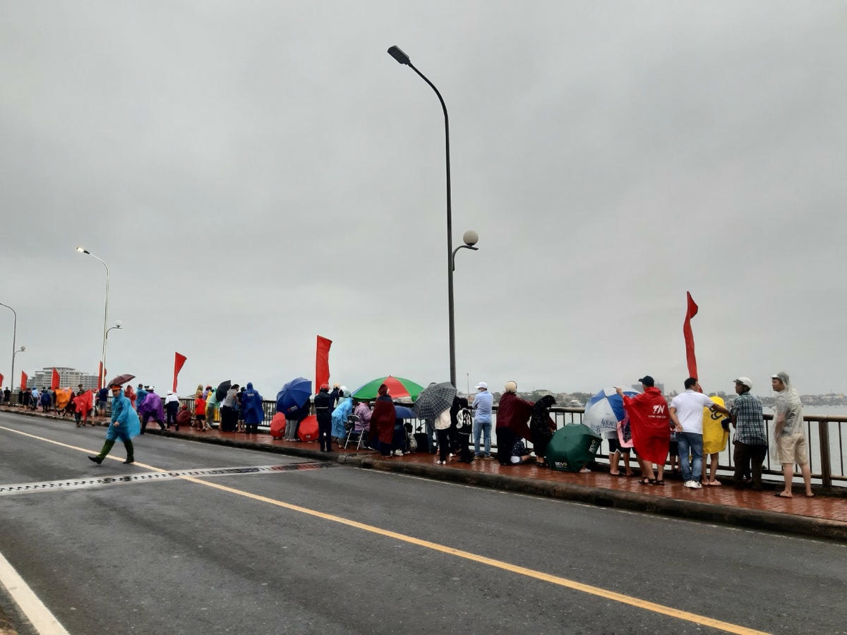 Người dân đứng cỗ vũ các thuyền đua trên Cầu Nhật Lệ I.