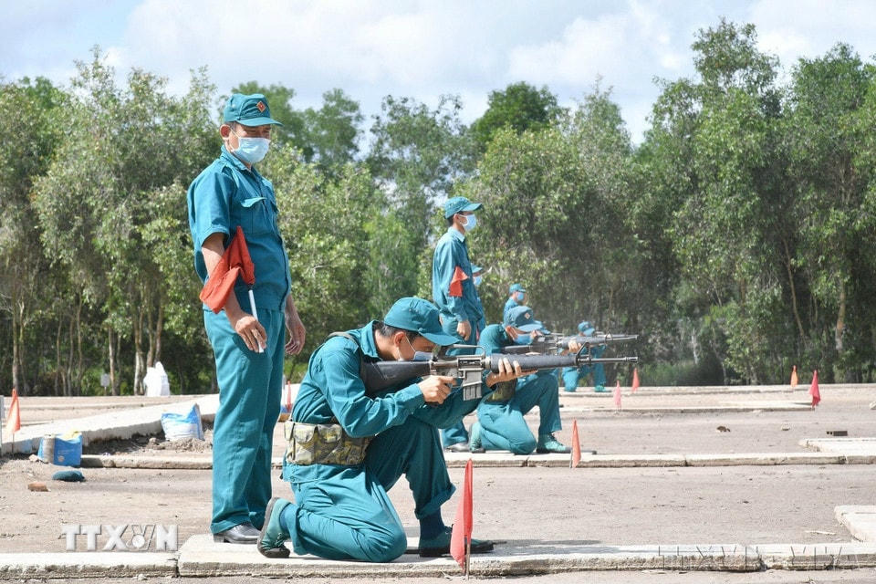Các dân quân thường trực thực hiện thao tác ngắm bắn mục tiêu cố định bằng súng AK trong kỳ huấn luyện quân sự, tháng 6/2021. (Ảnh: Hữu Chí/TTXVN)