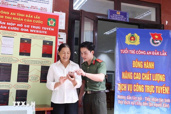 Tình nguyện viên Đội hình tình nguyện Công an tỉnh Đắk Lắk hỗ trợ người dân thực hiện thủ tục hành chính và thao tác cơ bản trên thiết bị điện thoại. (Ảnh: Hoài Thu/TTXVN) ttxvn-dak-lak-thanh-lap-110-doi-hinh-ho-tro-chinh-quyen-dia-phuong-2-cap.jpg